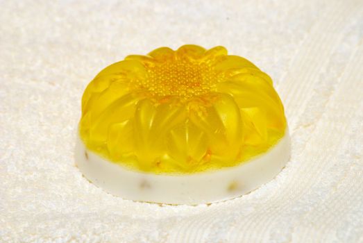 Natural Handmade Sunflower-Shaped Soap on a white towel.