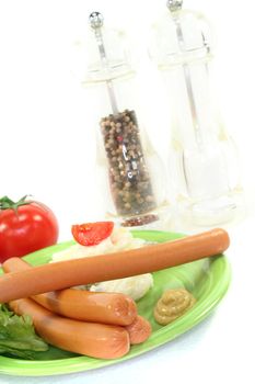 Wiener Sausage with potato salad and lettuce on a white background