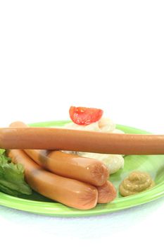 Wiener Sausage with potato salad and lettuce on a white background