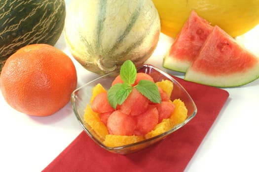 Melon orange salad with fresh peppermint in a bowl