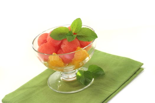 Melon orange salad with fresh peppermint in a bowl