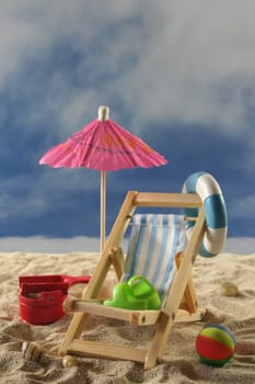 Deck chair with umbrella, water polo and swimming ring on the beach