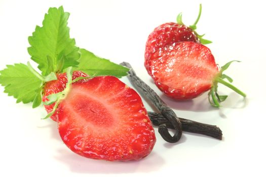 fresh half strawberries with vanilla on a white background