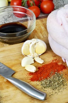 chicken, spices, knife, garlic and soy sauce on kitchen board