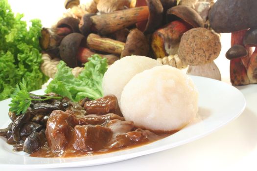 Game goulash with dumplings and fresh mushrooms