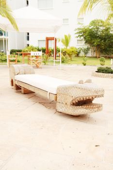 Home exterior patio with handcraft wooden sofa with an aligator appearance.