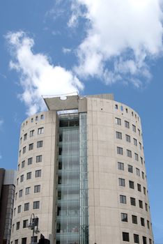 Unusual Round Office Block with External Elevator under a blue sky