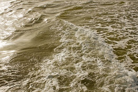 Foamy sea surface near the coast on a sunny day 