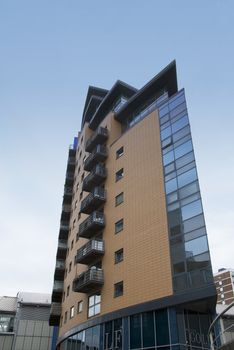 Angular Apartment Block built of brick and glass against a ble sky