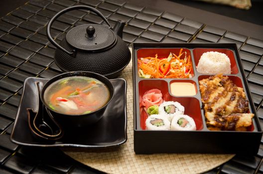Sushi lunch with soup salad tea and sauce