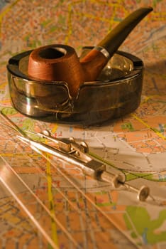 Shot of a map,pipe and compass ... looking for the way to go.