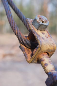 Close-up of rusting Eyelet Bolt with crimped stranded steel cable.