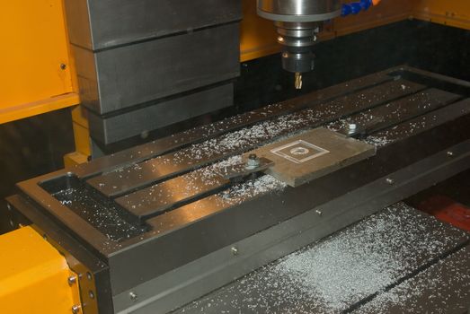 Drilling Machine automatically processing a metallic part.