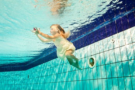 girl in the swimming-pool under water with a flower