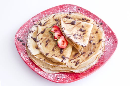 sweet pancakes with strawberries on red plate