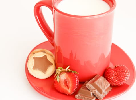 sweet meal with cup of milk and cakes and chocholate and strawberries