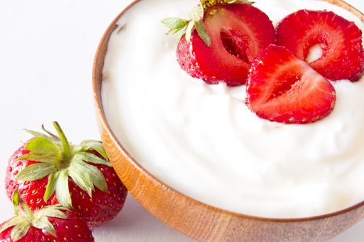 yogurt with strawberry in a wooden bowl