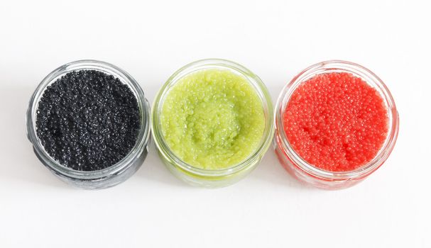 the red, green and black caviar in glass jars on withe background