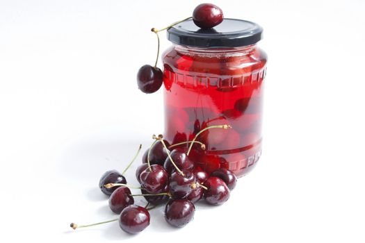 jar with red cherry against the white background