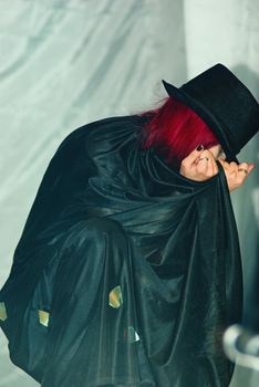 Redhead goth girl in a black coat and hat