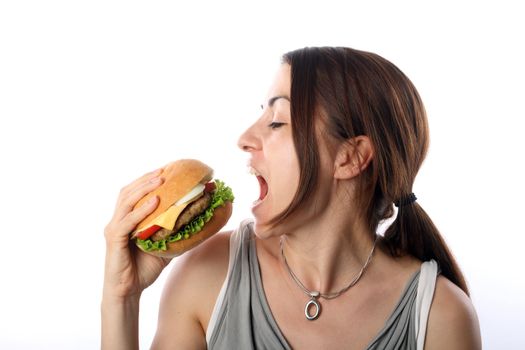 Young woman eating hamburger over white background