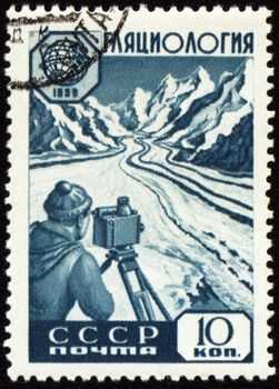 USSR - CIRCA 1959: stamp printed in USSR, shows glaciology researcher with device at glacier in mountain, 

circa 1959