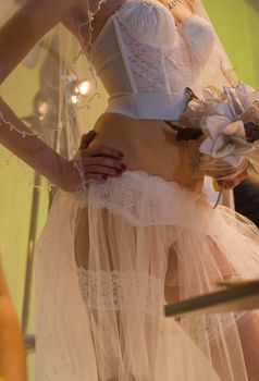 The bride in corset with a wedding bouquet