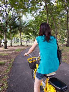 One woman carry fashion bag while starting bike in the park