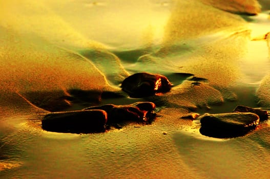 Stones on wet sand on an ocean coast