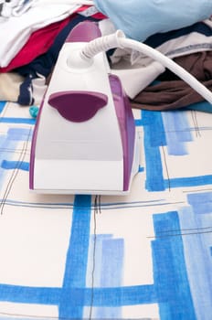Ironing - Iron and Heap of Landry on Ironing Board