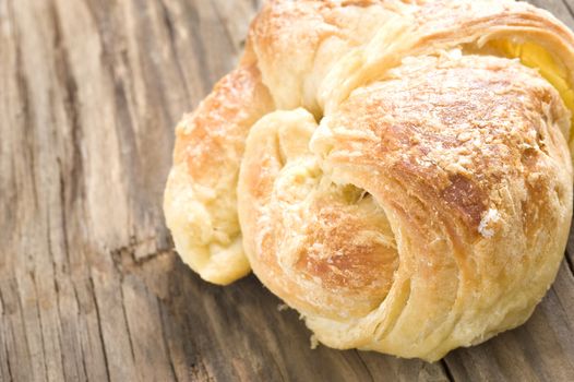 Close up of freshly baked croissants on a wooden surface