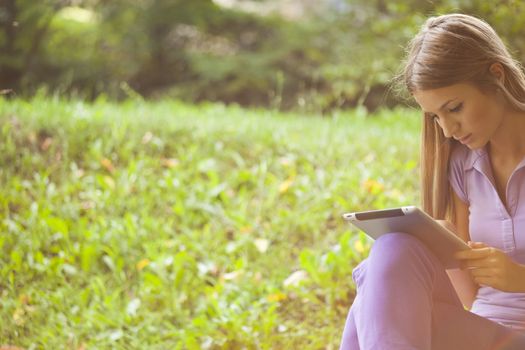 Beautiful Young Woman With Tablet Computer In Park