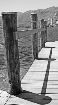 White and black close up of poles of a pier