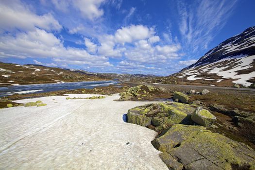 Road across the snowy landscape in Norway, summertime