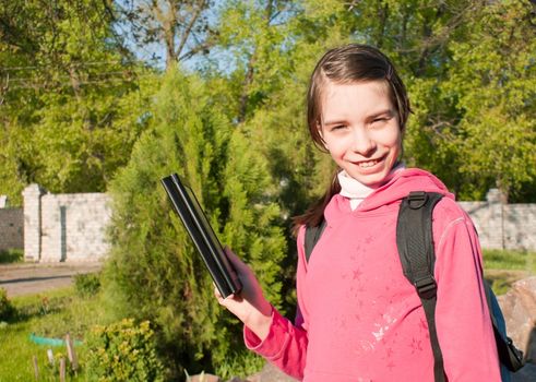 Teen girl with e-book reader outdoors