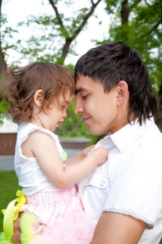 The father and the daughter together lay on a grass