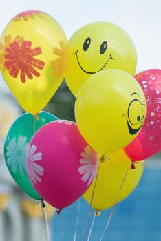 A smiley faced balloon in the blue sky