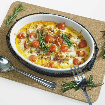 baked white asparagus with cherry tomatoes on rosemary