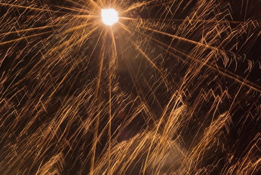  Many golden fireworks bursts at fireworks festival.