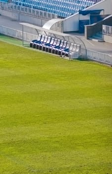 Benchwarmers on an empty soccer field