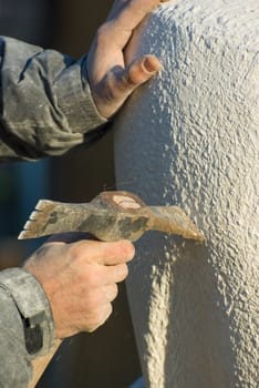 Stonecutter carves with a pick sculpture of limestone
