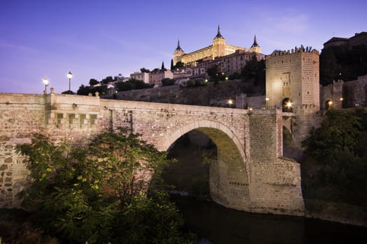 Panorama of the alcazar above the medieval San Martin bridge - Toledo, Spain