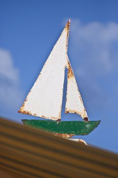 An old, rusty, retro, vintage, sailing boat sign.