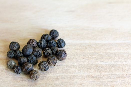 Black Pepper grains in the bottom left corner of the chopping board