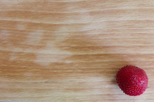 Cutting board with strawberry in bottom right corner