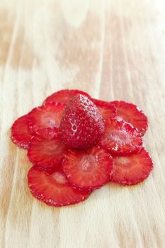 strawberries slices composed as flower on the cutting board