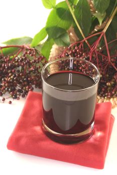 Elderberry juice with elder berries on a branch with leaves