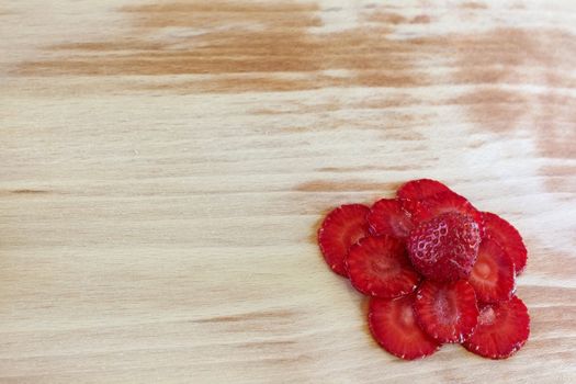 strawberries slices composed as flower on the cutting board in the right bottom corner