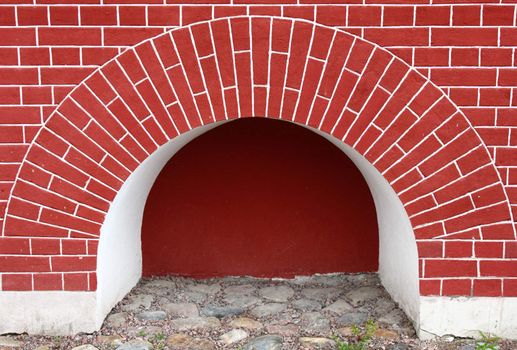 Niche in red brick wall with brick arch