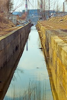 old gutter channel empties into the river